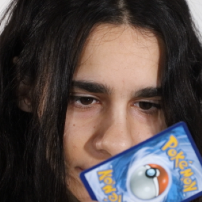 woman holding pokemon card to face